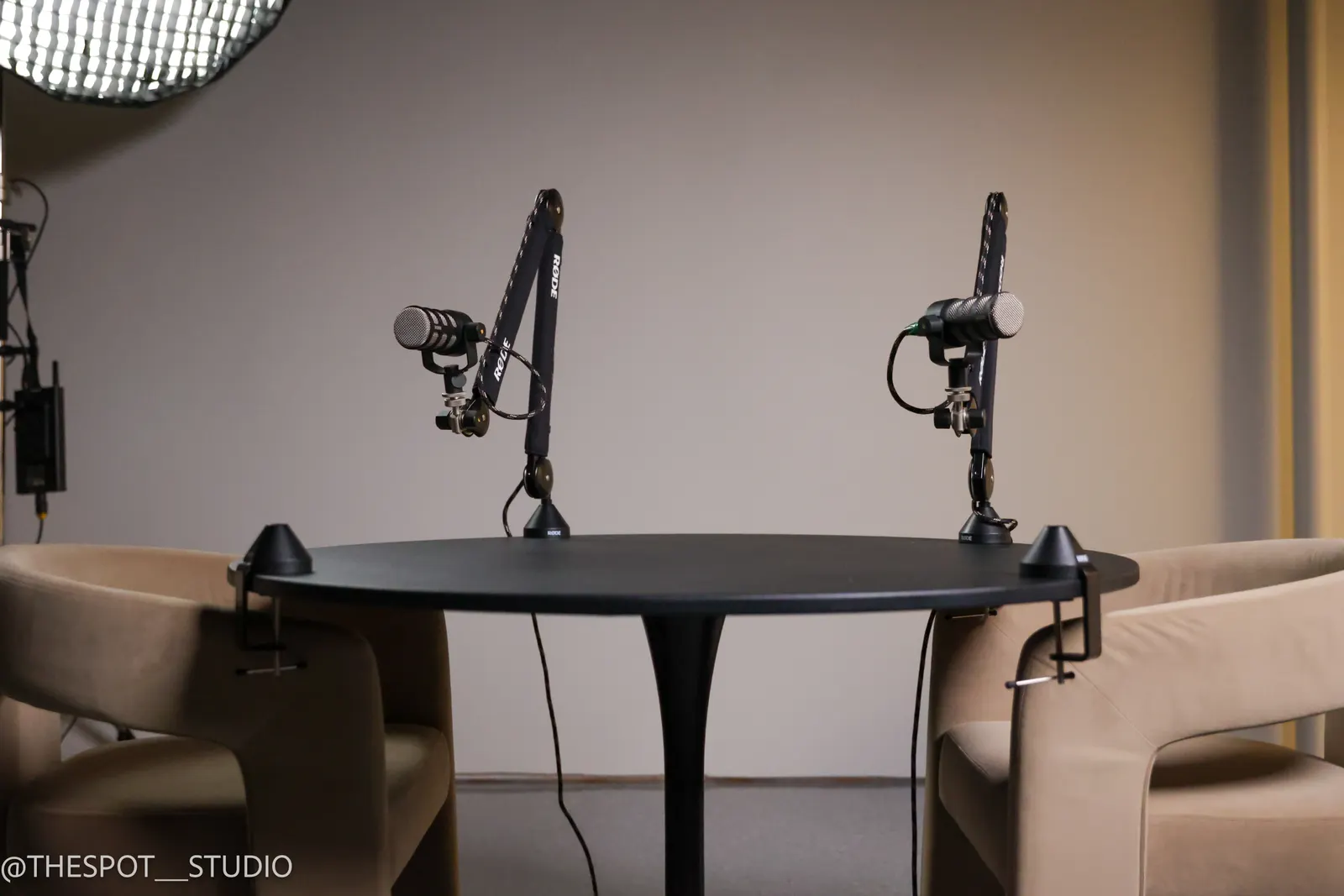 Podcast table with two microphones and softbox lighting in the Garage Room